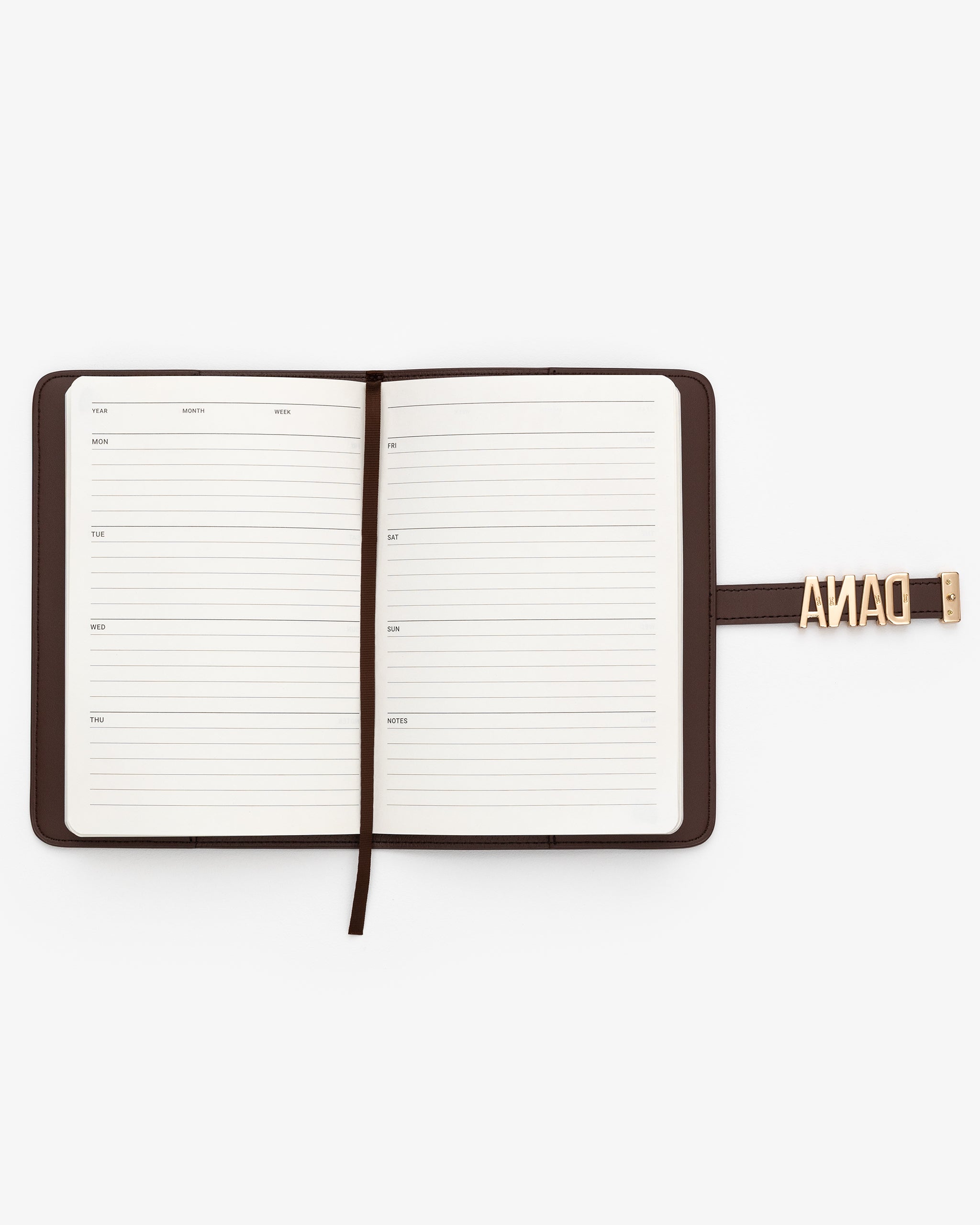 Open planner with a brown strap and 'DANA' personalisation on a white background
