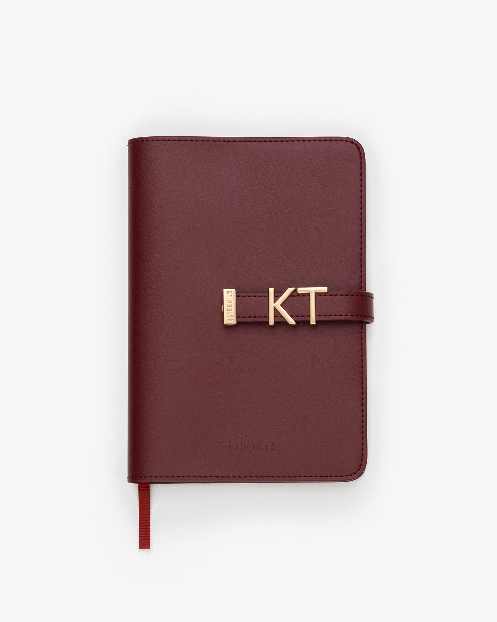 Oxblood notebook with gold personalisation 'KT' on a white background