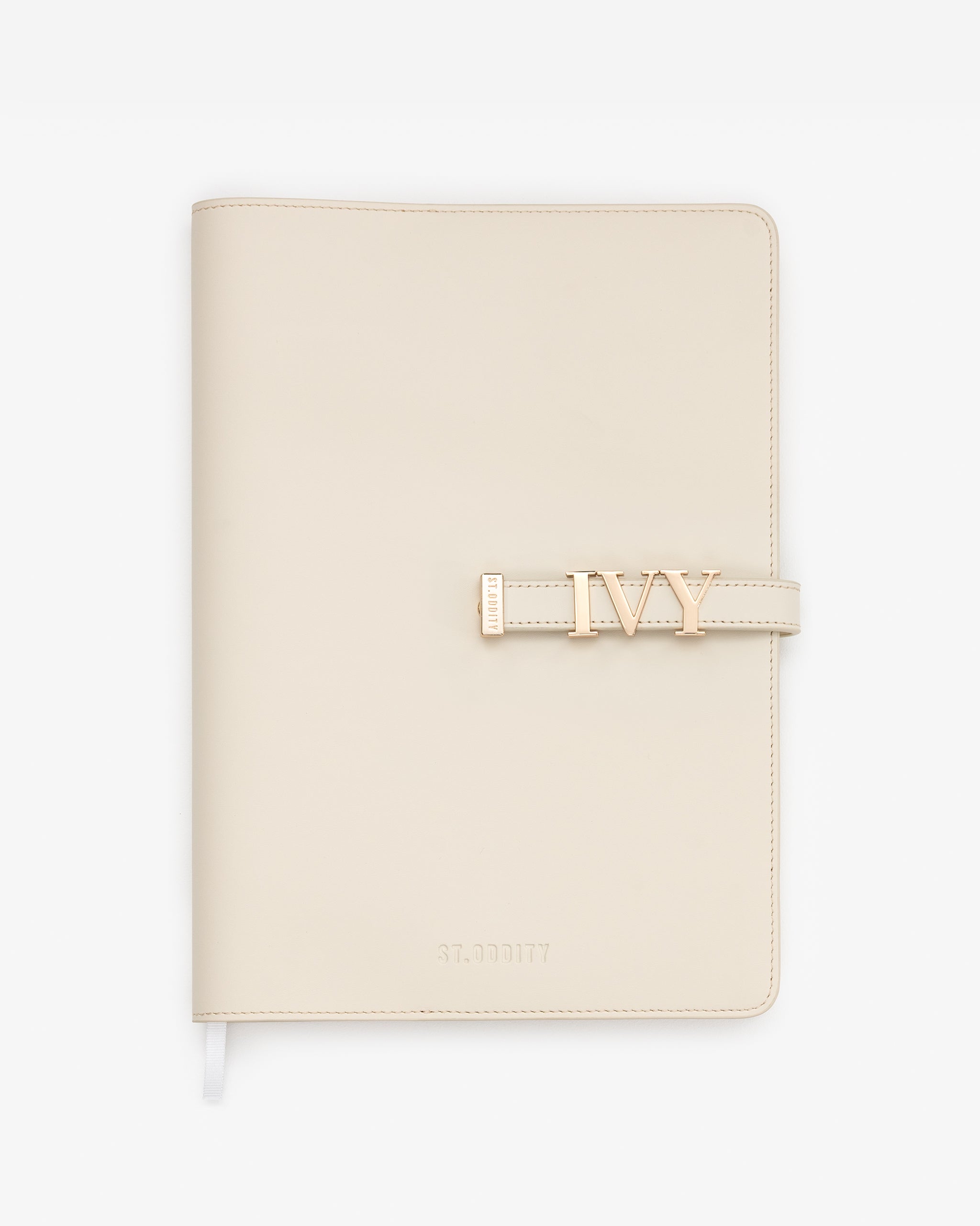 Off white A4 Notebook personalised with 'IVY' in serif gold hardware on a white background.