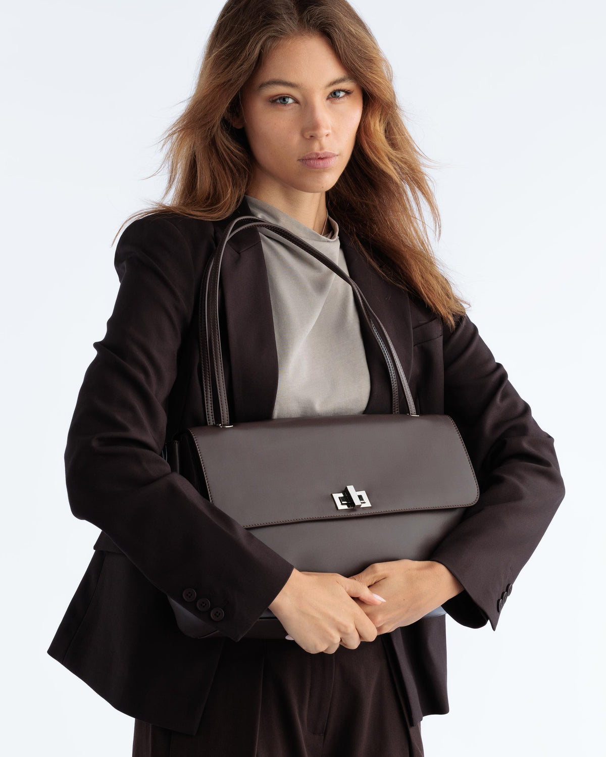 Espresso coloured commute shoulder bag worn on a female model