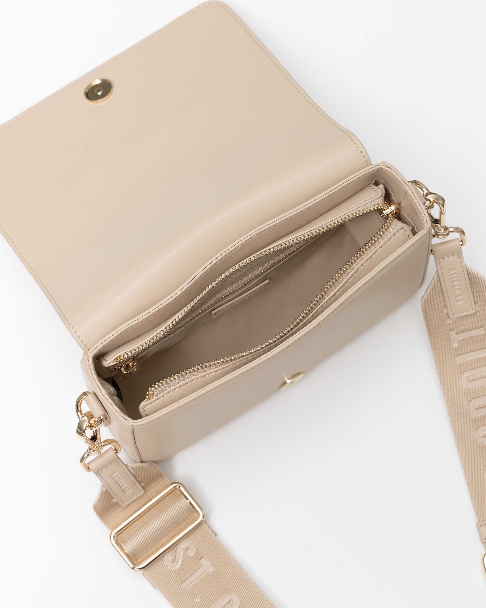 A beige crossbody bag with a wide matching fabric strap, shown open to reveal a zippered interior. The bag features gold-tone hardware and a small gold snap button on the front flap, photographed on a clean white background.