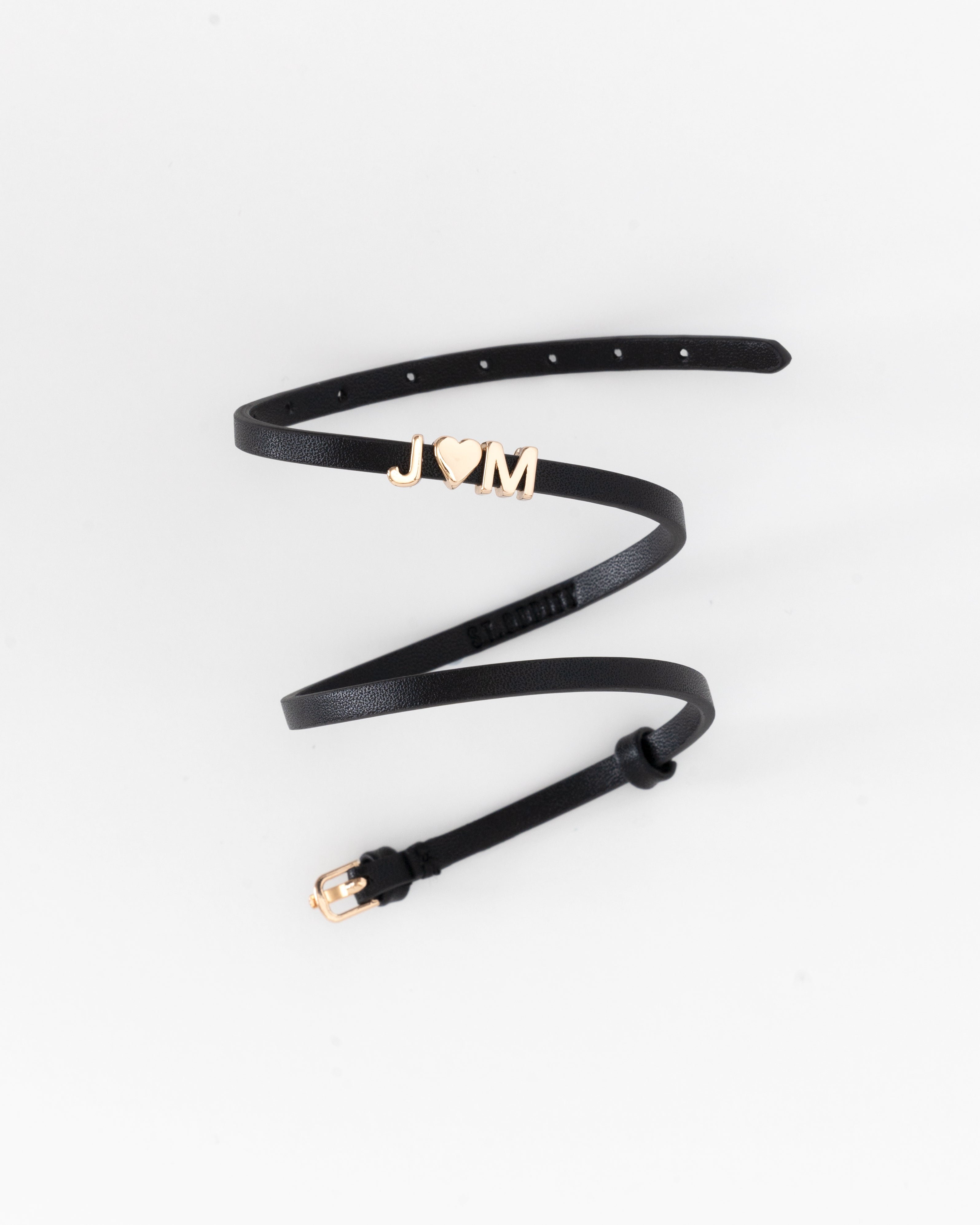 Black vegan leather bracelet with 'JM' in gold letter personalisation on a white background.
