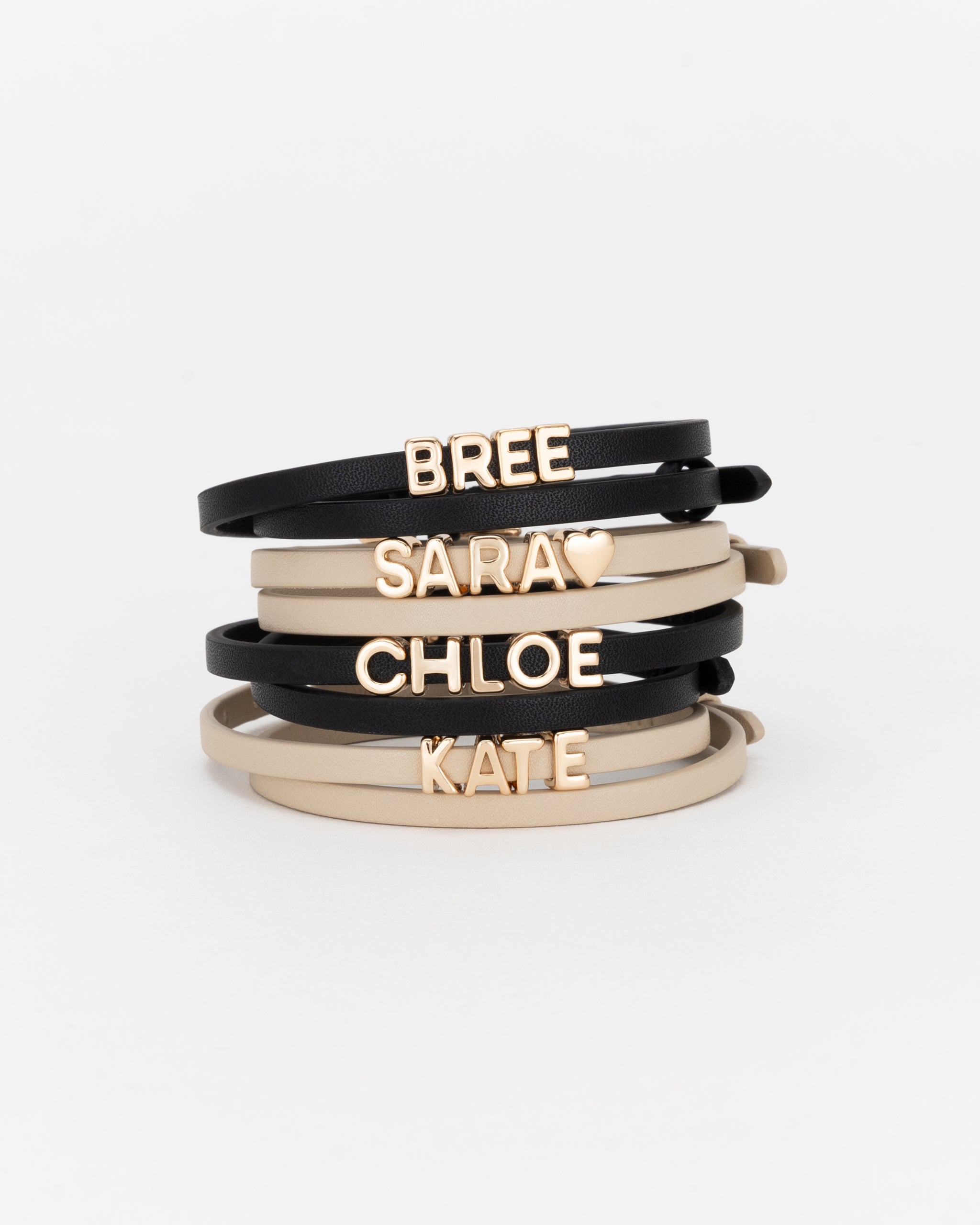 Personalised bracelets stacked in black and light sand with gold letters.