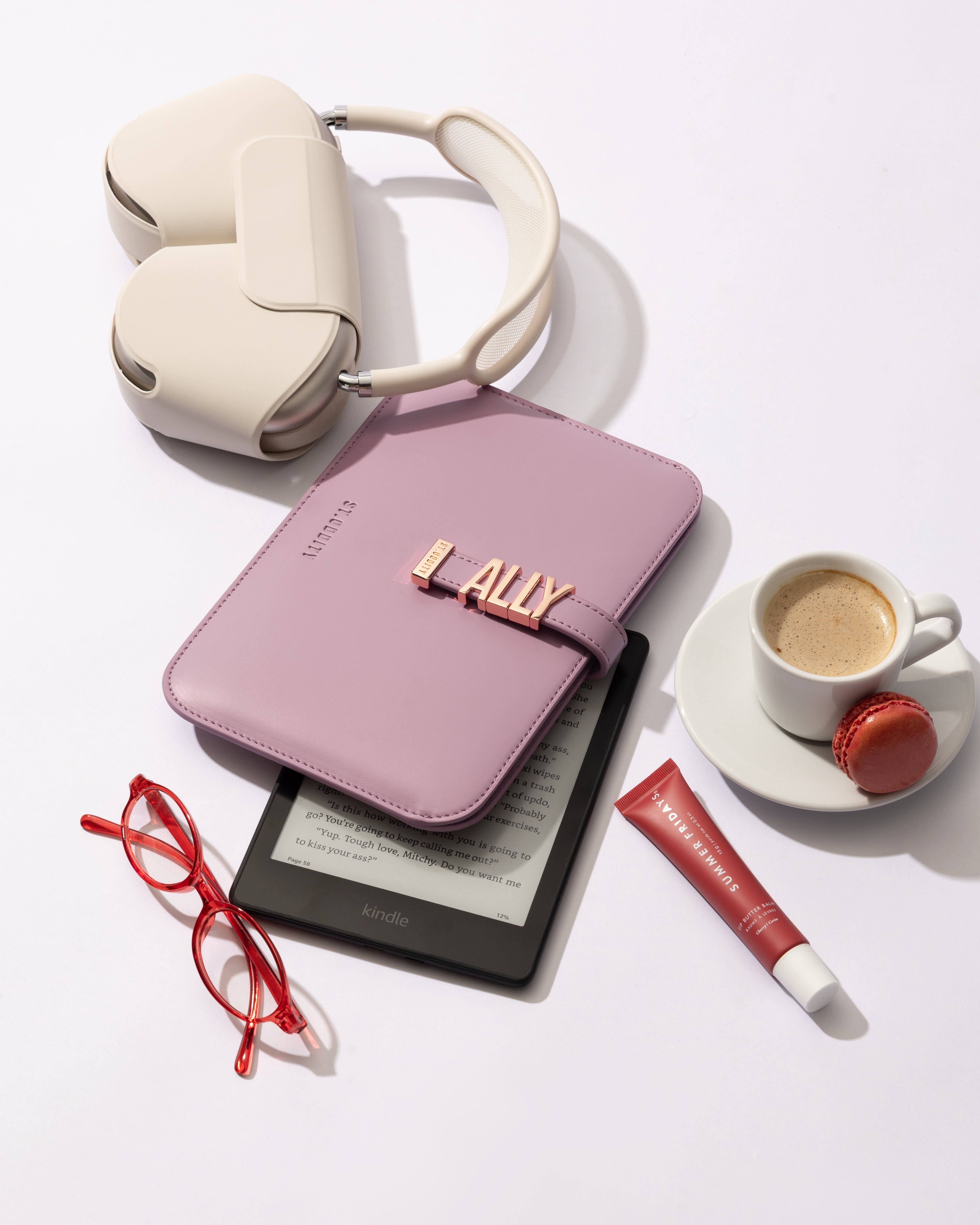 Lilac iPad/kindle sleeve with gold personalisation with essential items on a white background