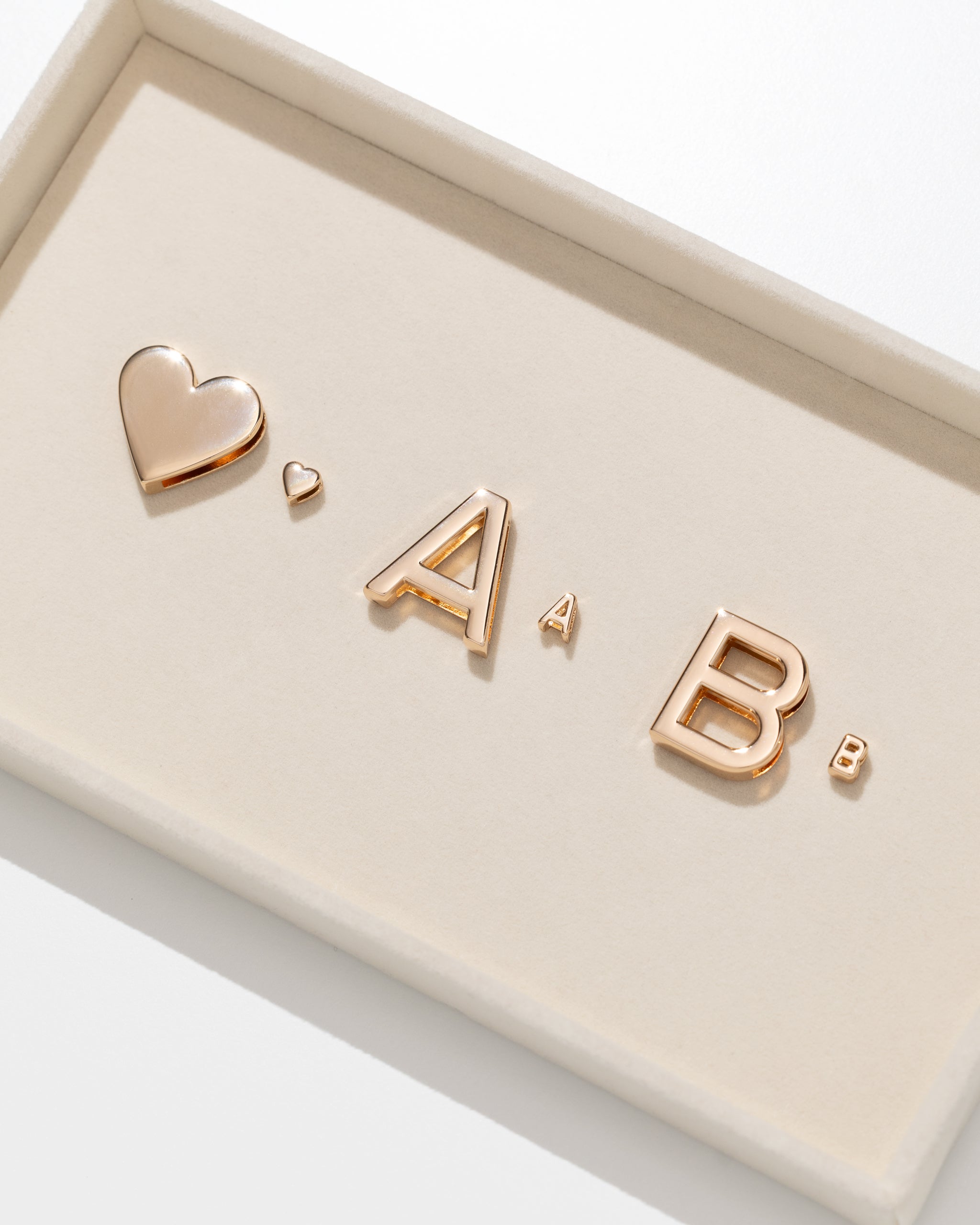 Comparison of large and micro letters in gold on a felt tray.