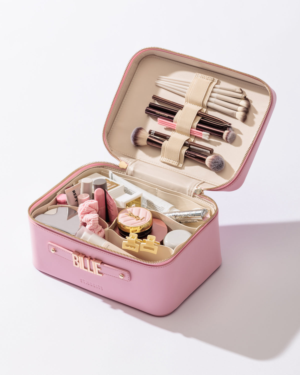 Vanity Case in Pink with Light Beige lining filled with brushes and cosmetics.