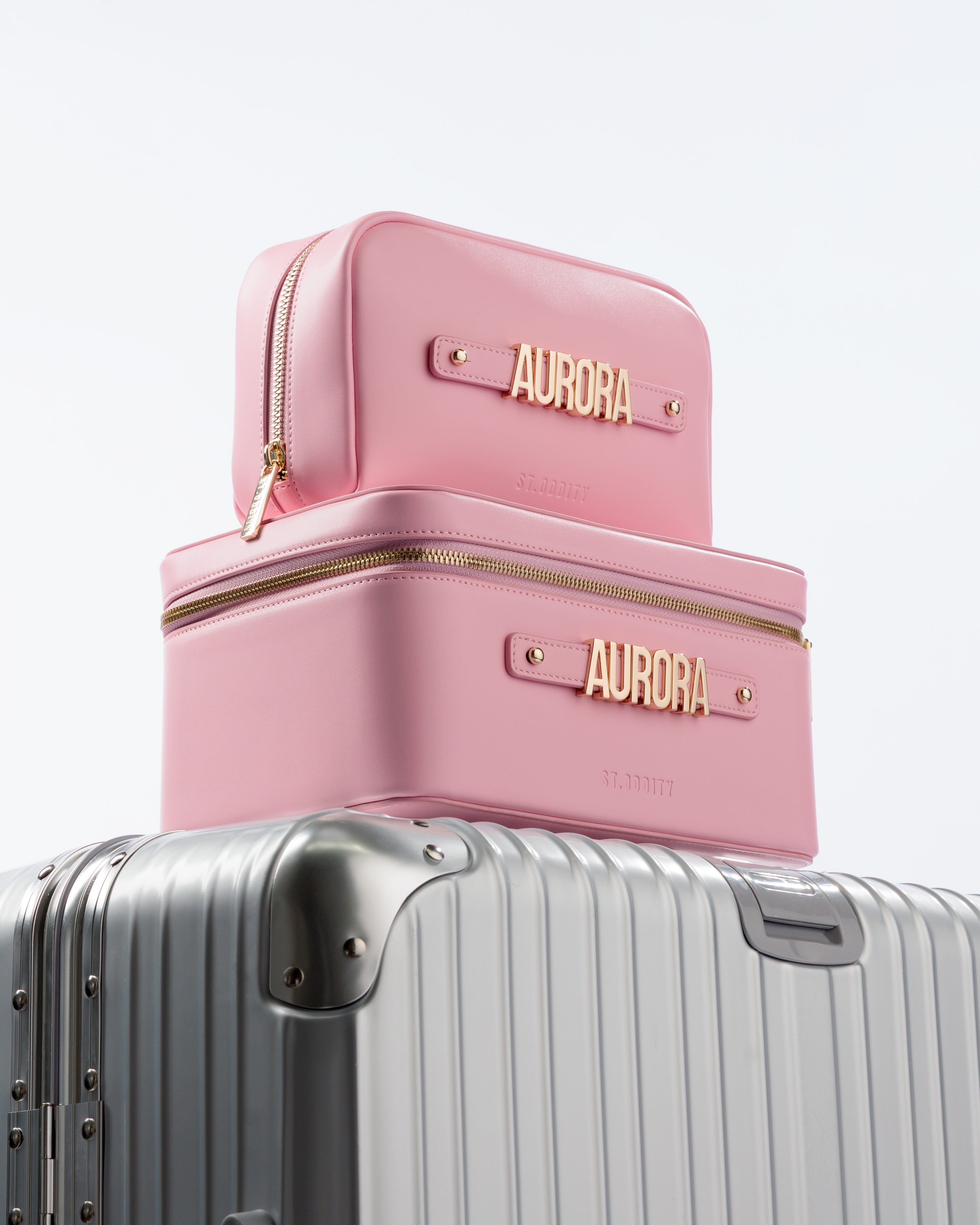 Pink pouch and makeup case with 'AURORA' personalisation on silver luggage