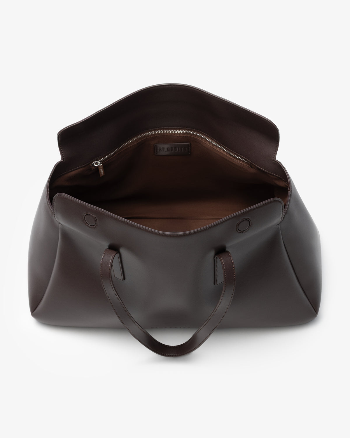 A dark brown leather tote bag shown from a top-down view, open to reveal a brown interior lining and a zippered compartment. The bag features two leather handles and is photographed on a clean, light gray background.