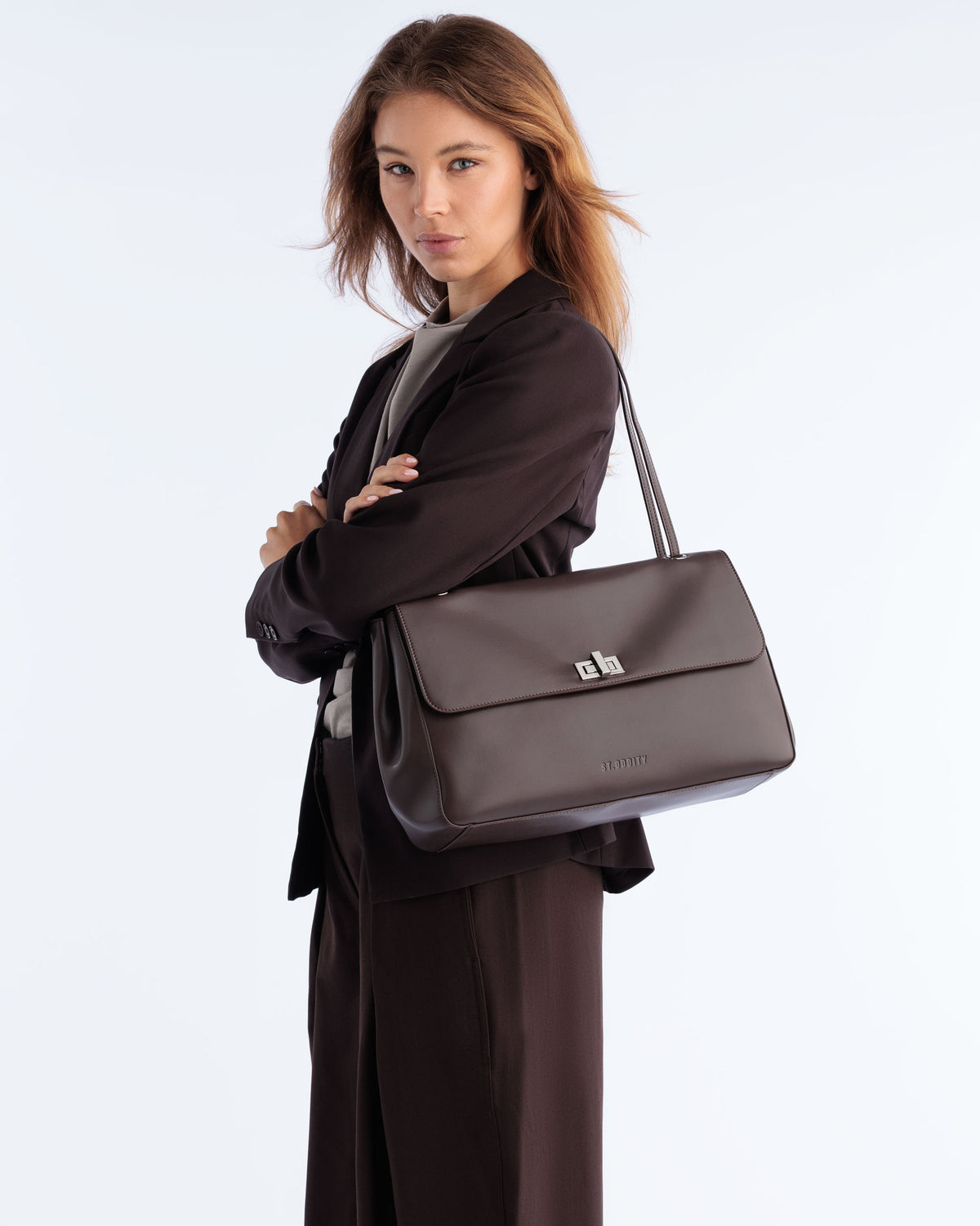 Model carrying the Commute Shoulder Bag in Espresso