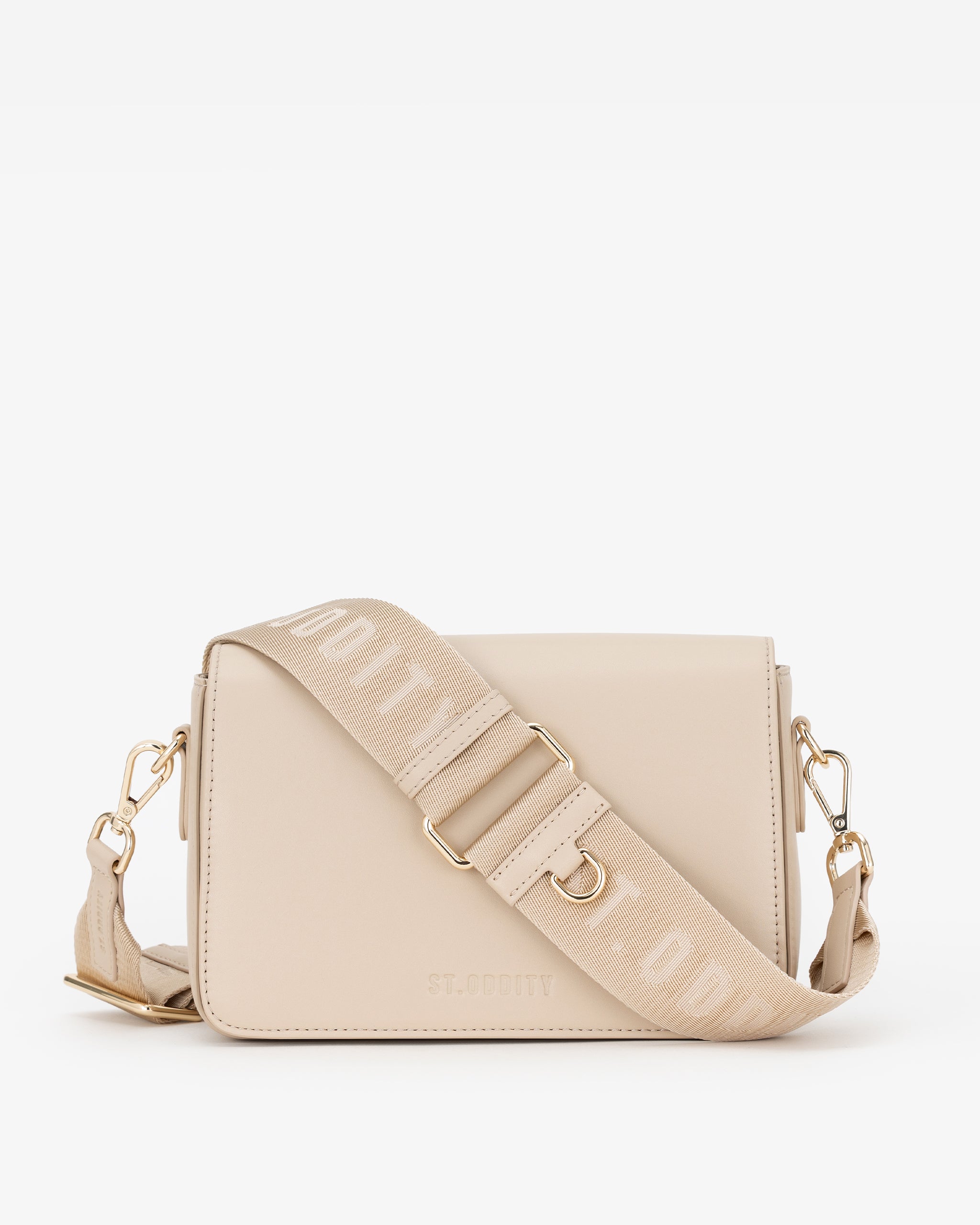 A light beige leather crossbody bag with a matching fabric shoulder strap featuring the brand name 'ST. ODDITY'. Shown against a plain white background.