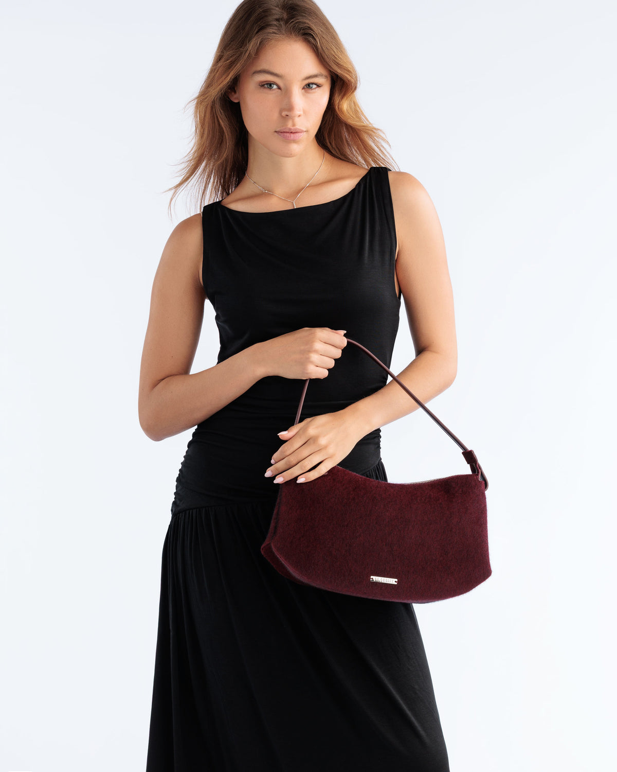 Model carrying the Detour Shoulder Bag in Burgundy