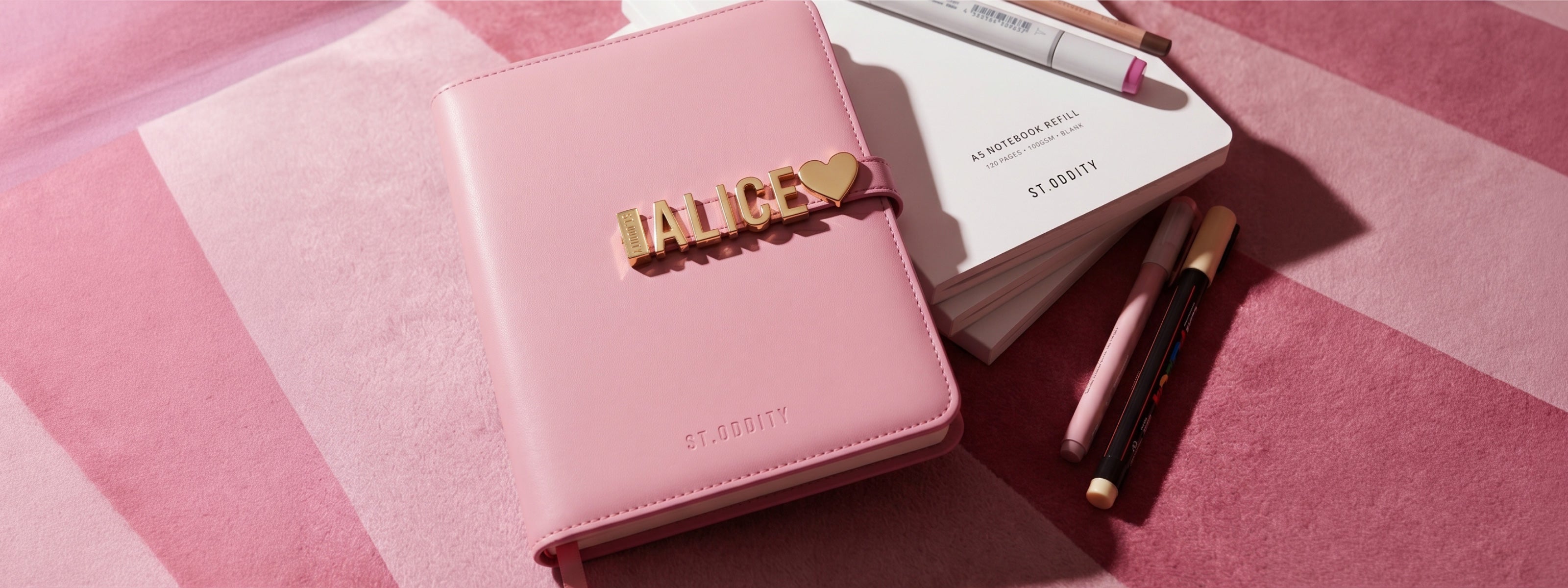 Pink notebook with 'ALICE' personalisation on a pink and white striped background.