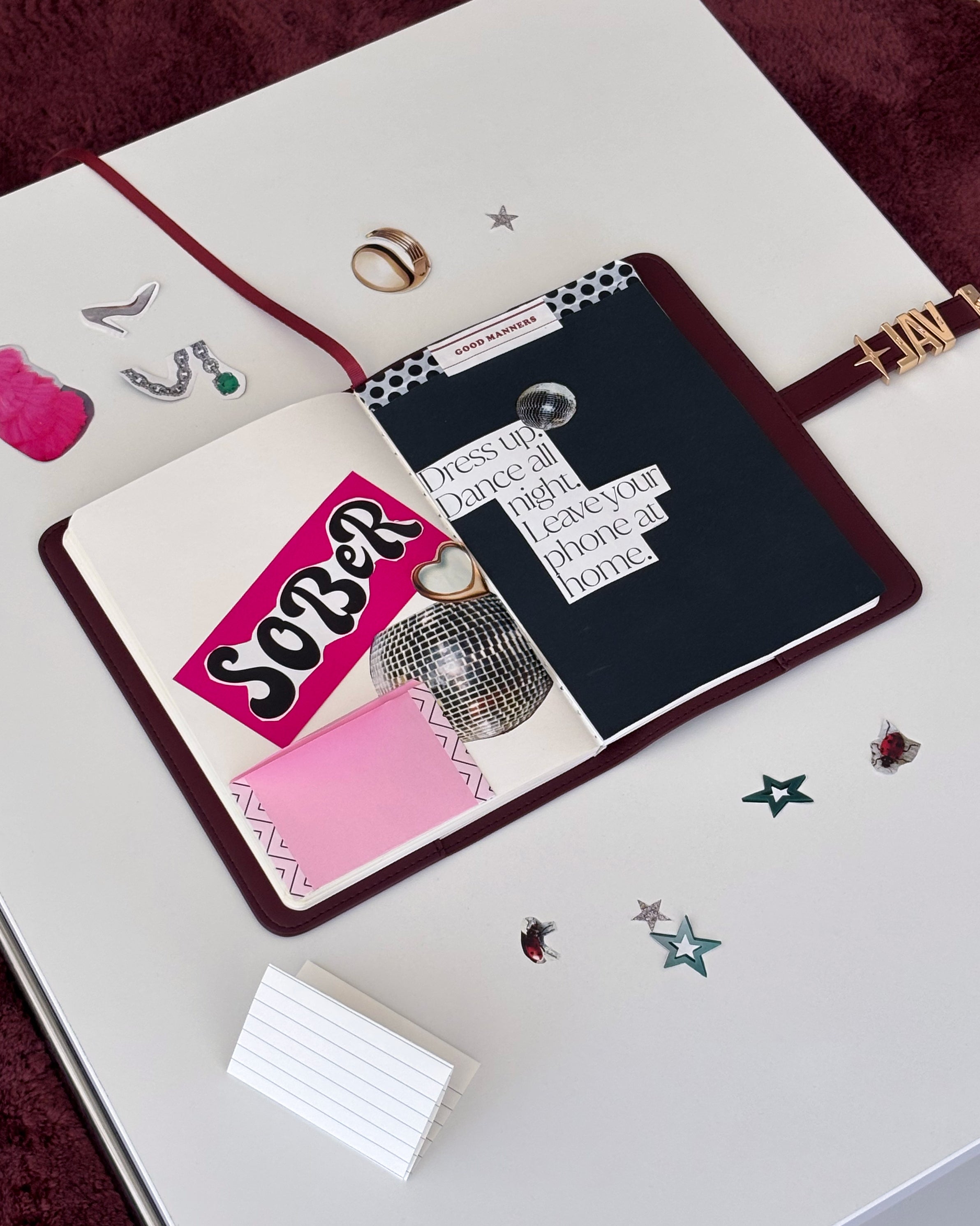 Open book with decorative pages and a scrapbooking sticker on a white surface.